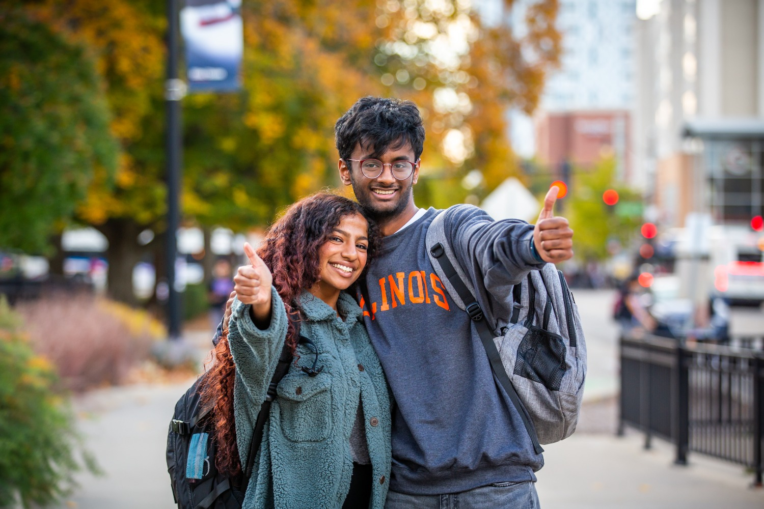 two people embracing on sidewalk and smiling