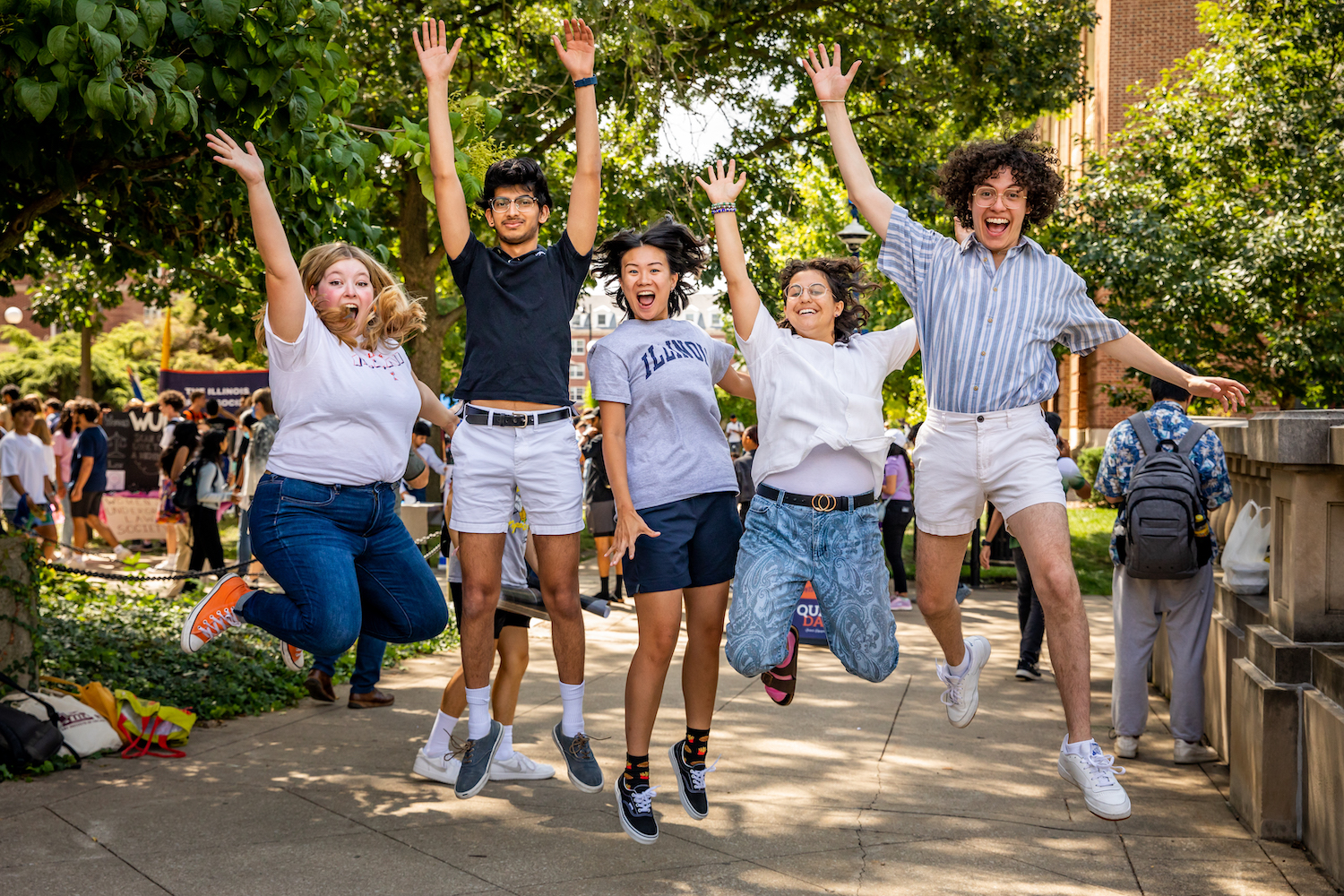 students jumping in celebration on campus